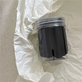 Primer plano de gomas de pelo negras en un práctico contenedor cilíndrico transparente - Negro puro