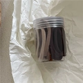 Gros plan d'élastiques à cheveux crème assortis dans un pot de rangement transparent - Couleurs café