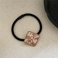 Detail of square marble acetate hair tie with golden metal edge on stone background - Off-White Marble Pattern