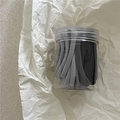 Primer plano de gomas de pelo elásticas en un frasco de almacenamiento sobre fondo blanco - Gris Oscuro