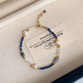 Nahaufnahme von Naturstein-Armband mit Süßwasserperlen und goldenem Karabinerverschluss - Lapislazuli Armband
