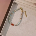 Bohemian style bracelet with mixed natural stones and gold metal spacers on jewelry tray - Red Agate Bracelet