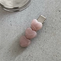 Detailed macro view of three pink marble-textured hearts on a silver duckbill hair clip - Pink