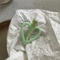 Vue détaillée d'une pince à cheveux en forme de cœur vert clair avec une finition mate - Vert Pâle