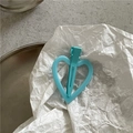 Gros plan d'une pince à cheveux cœur bleu clair sur fond de papier blanc texturé - Bleu clair
