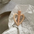 Detailed close-up of a matte peach heart-shaped cutout hair clip on a metal tray - Dusty Pink