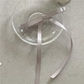 Dettaglio del fiocco in raso champagne con nastri lunghi su piatto di vetro - Fiocco con Nastro (G4.2) / Clip a molla / Grigio