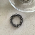 Detailansicht eines grauen Kristall-Haargummis mit mehrlagigen geometrischen Glasperlen - Gunmetal-Schwarz