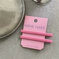 Détail de deux pinces à cheveux en alliage rose mat sur une carte avec texte fait main - Rose Bonbon