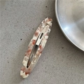 Macro view of long oval acetate hair clip with pink and white marble texture on metal base - Willow Leaf Snap Clip / Pink & White