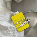 Detail view of cream-style polka dot hair clips on a decorative yellow display card - Cream White Willow Leaf Polka Dot Style