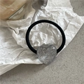 Nahaufnahme eines glitzernden silbernen Herz-Ornaments am schwarzen Haargummi - Silber Herz Haargummi (Silber Herz Elastisch)