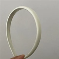 Dettaglio del cerchietto in raso bianco crema con design imbottito e consistenza liscia - Bianco Sporco