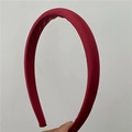 Dettaglio di un cerchietto imbottito rosso scuro con elegante finitura satinata - Borgogna