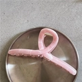 Dettaglio di una pinza per capelli con motivo in marmo rosa e molla in metallo dorato - Trama Marmo Rosa (B6.1)