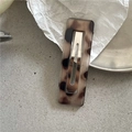 Detailaufnahme einer rechteckigen Haarspange mit Leopardenmuster und geometrischem Design - Weißer Leopard