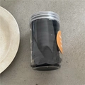 Detailed top view of 48 black high-elastic hair ties in a clear plastic jar - Black