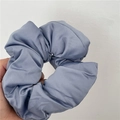 Detailed close-up of gray-blue satin scrunchie showing the soft silk texture and pleats - Blue