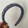 Dettaglio di un cerchietto grigio imbottito con cuori rossi ed etichetta fatta a mano - Blu (Stampa Cuore)