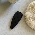 Dettaglio molletta per capelli in tessuto jacquard a cuori su superficie minimalista - Goccia Corta Cuore Nero