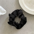 Detailed view of the smooth black satin fabric and ruched texture of this hair scrunchie - Small / Black