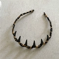 Vista detallada de diadema con estampado de leopardo y púas cónicas negras estilo punk - Textura Caqui Negro