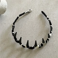 Detalle de la diadema forrada en tela con puntas decorativas negro mate sobre piedra - Mármol Blanco y Negro