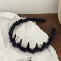 Detail of purple plush headband with black punk spikes on wood and white paper - Deep Blue Purple