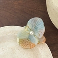 Close-up of marble acetate orchid hair clip with blue and orange texture and pearl - Blue Orange