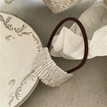 Dettaglio della texture metallica ondulata dell'elastico su un piatto di ceramica - Stile Porta Coda di Cavallo Increspato / Argento