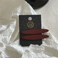 Macro view of two burgundy alloy hair clips on a handmade decorative card - Willow Leaf Style