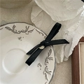 Dettaglio del fermaglio per capelli a fiocco in pelle nera con fibbia in metallo dorato - Nero (Placca Oro)