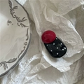Dettaglio di un fermaglio per capelli retrò con pois rossi e neri su sfondo bianco materico - Nero (Sfera Rossa)