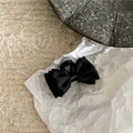 Detail einer schwarzen Haarklammer mit Satinschleife und eleganter seidiger Textur - Schwarz