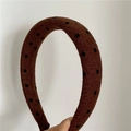 Detail eines hochwertigen braunen Woll-Stirnbands mit schwarzem Polka-Dot-Muster-Strukturen - Dunkelkaffee (Grob)