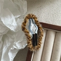 Detail of plush leopard print hair clip showing soft faux fur texture on a wooden box - Khaki Clover