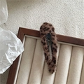 Primer plano de una pinza de pelo de felpa leopardo marrón en bandeja de terciopelo - Café Gota de Agua