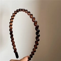 Detail of translucent amber wavy hairband with anti-slip sawtooth resin structure - Brown