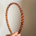 Primer plano de diadema ondulada de resina ámbar con elegantes texturas negras - Naranja (Con líneas negras)