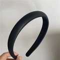 Close-up of black litchi texture PU leather headband with thick padded design - Black