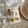 Detaillierte Nahaufnahme handgefertigter Haarklammern aus Filz und Pompons auf Karte - Kleine Ente Stil / Enten Clip