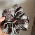 Macro shot of large pleated scrunchie with classic green and purple plaid fabric texture - Green Plaid Scrunchie