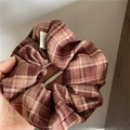 Close-up of a plaid hair scrunchie in brown and beige with a Hand Made label detail - Brown Plaid Scrunchie