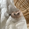 Détail d'une pince à cheveux cœur en peluche marron clair sur fond blanc minimaliste - Café