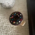 Detail einer Wollfilz-Donut-Haarklammer mit bunten Streuseln und schokoladenbraunem Bezug - Donut