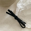 Close-up of black suede bow hair clip with metal duckbill base on artistic white paper - Black
