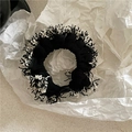 Dettaglio di un elastico a frange monocromatico con trama di peluche su carta bianca - Pizzo con nappe / Nero