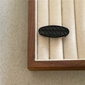 Detailaufnahme der schwarzen ovalen Haarklammer mit strukturierter Kunstleder-Oberfläche - Schwarzes Oval
