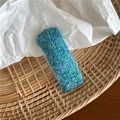 Gros plan d'une pince à cheveux rectangulaire tissée bleue et verte en mohair - Cyan