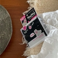 Dettaglio di elastici neri in una scatola a forma di coniglio su tavolo in legno - Piccoli Anelli in Scatola / Stile Coniglio Grigio Nero